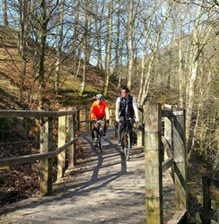 Photo 2 shows: cyclists enjoy the raised boardwalk section of the Keswick to Threlkeld Railway Path, which reopened on 18 March following the December floods.