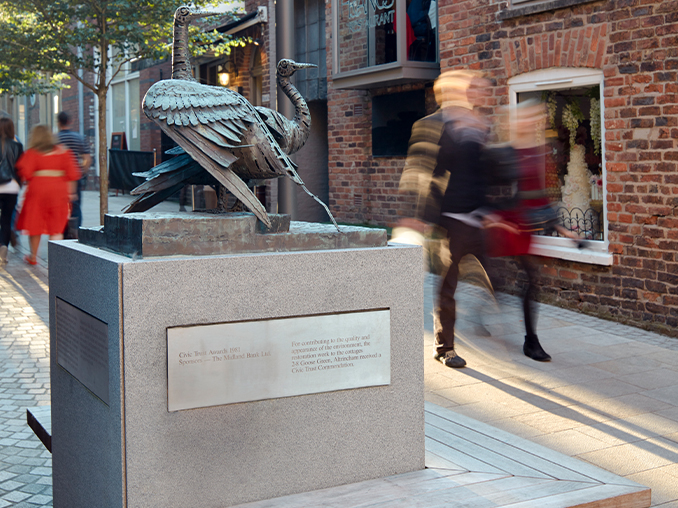 A statue and seating in a city street.