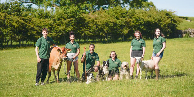 farmers and animals standing in a field