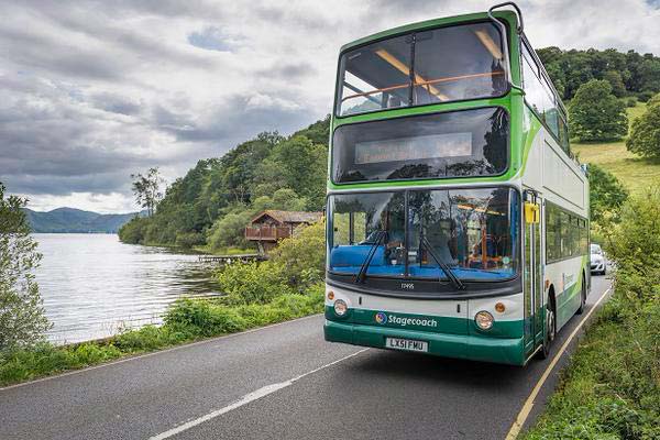 A bus driving along a lake side road