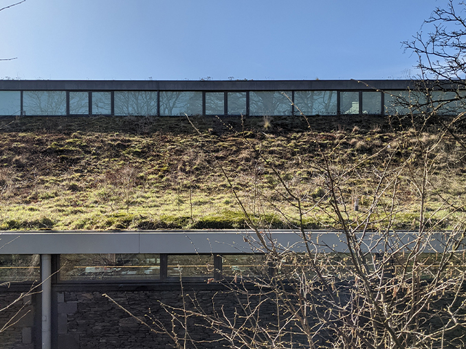 A moss and plant covered roof on a modern building. 