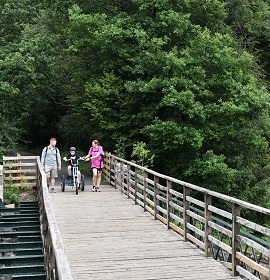 Photo shows a young family cycling rather than using their car on the newly improved Keswick to Threlkeld Trail, as a new Lake District sustainable travel learning resource in launched for teachers.