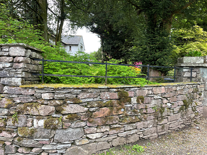 Stone wall with metal railings above.