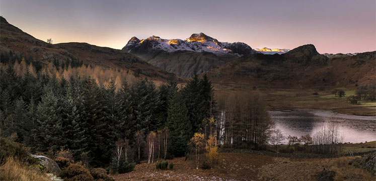 Blea Tarn with the Langdale fells on the horizon capped with snow