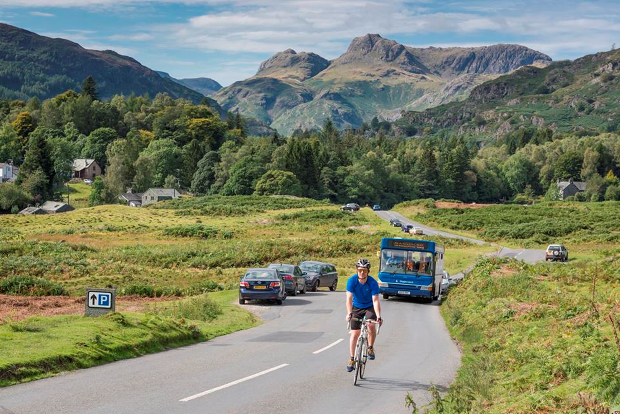 photo of cyclist and a bus with langdale hills in the backdrop