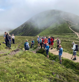 A fix the fells work party briefil at Sail near Keswick with an upland path in view in the distance 