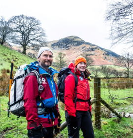 JOn Bennett and Kath Jackson smile at camera with hills behind on a spring day 