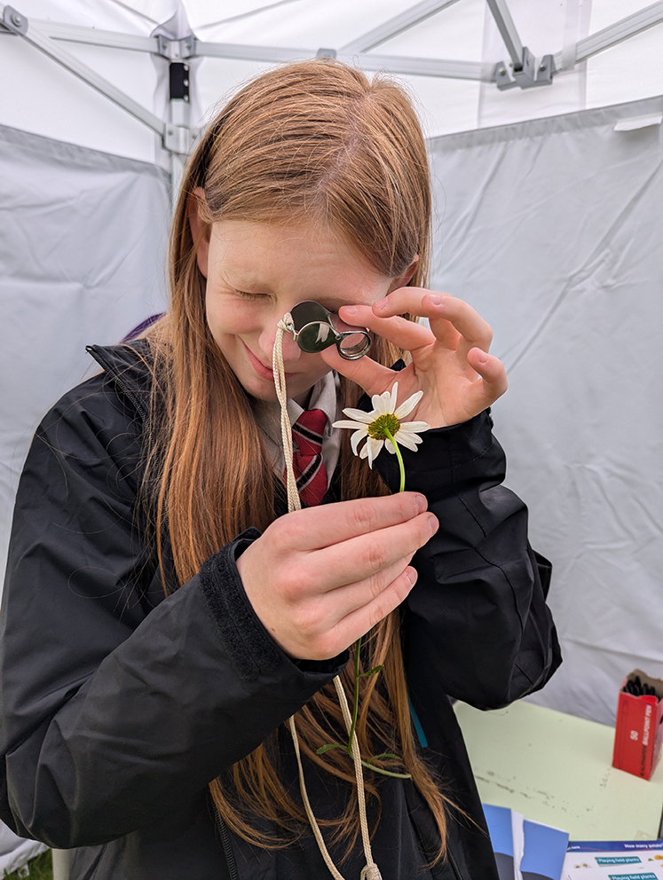 Green Skills Day - photo of pupil looking at flower with magnifying glass