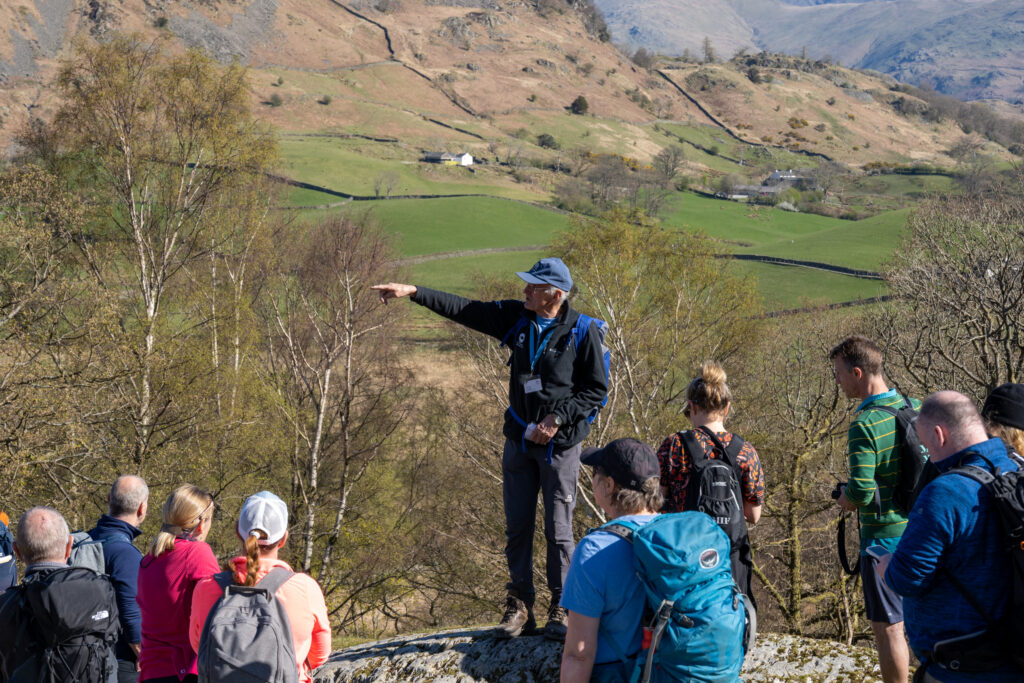 Volunteer talking to a group of people on a guided walk in the Lake District National Park