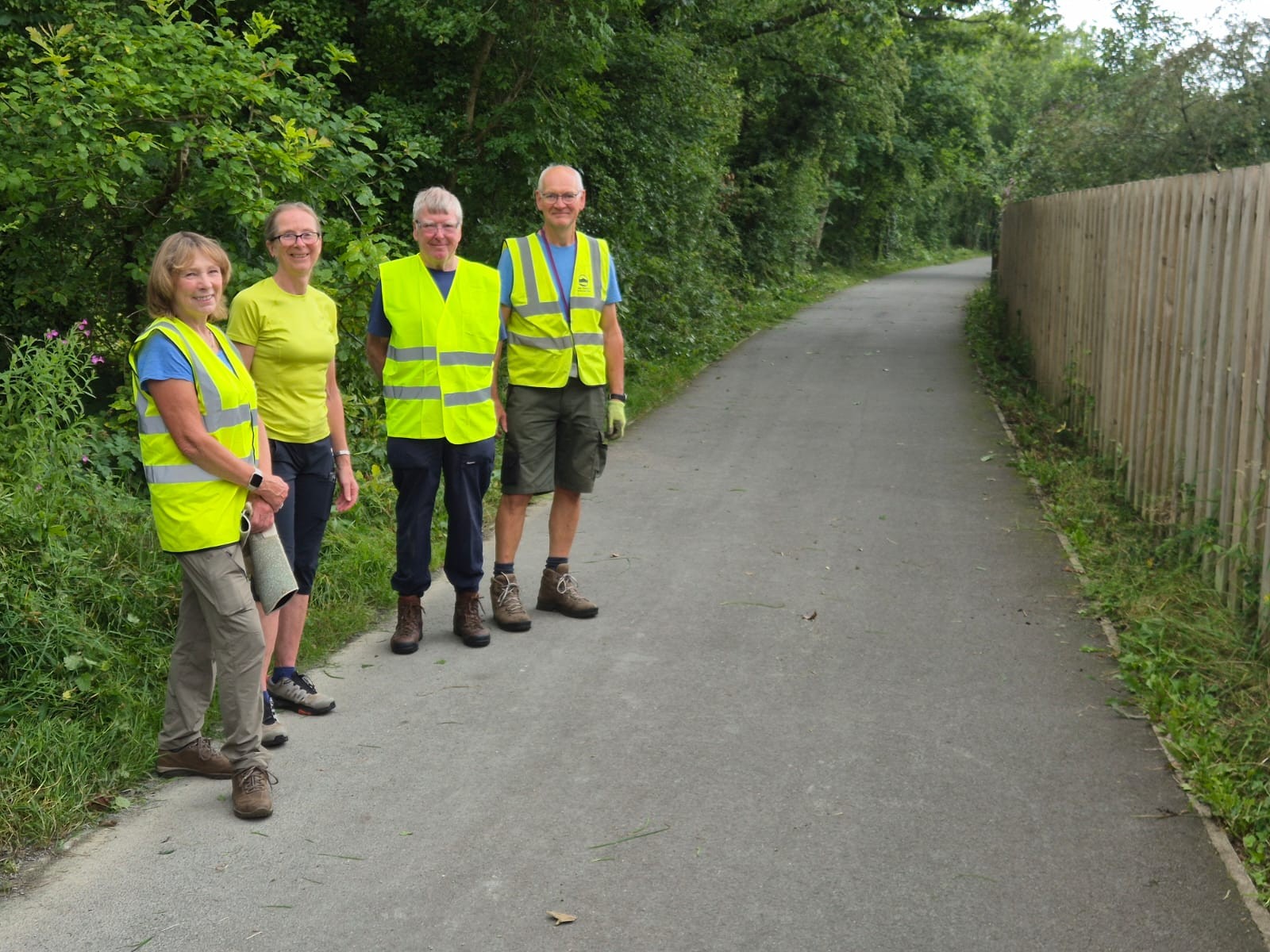 Volunteers in high vis vests showing a clear path they have worked on.