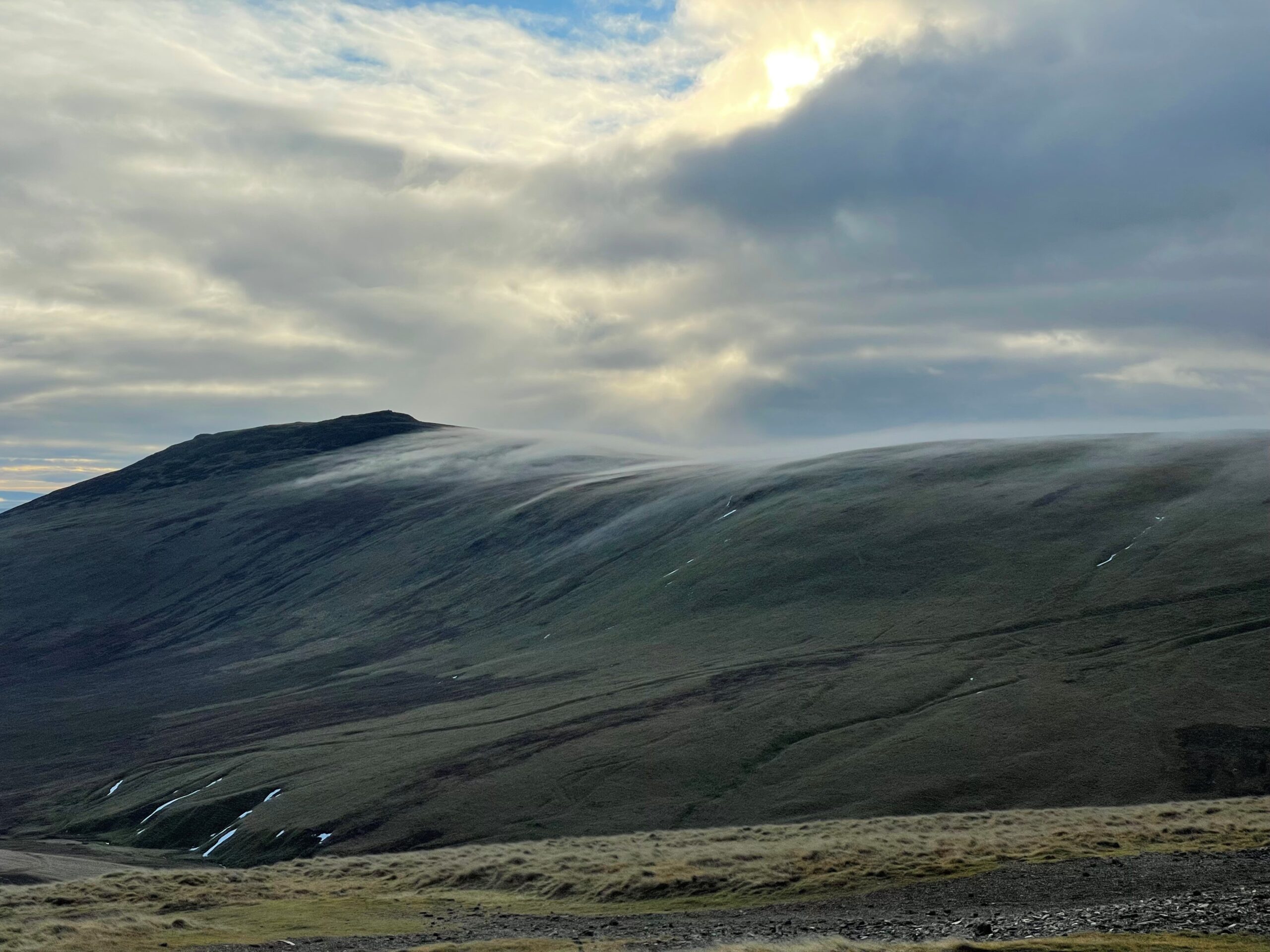 Caldbeck Common in the Lake District, a fell on an overcast day with cloud rolling along the top of the fell