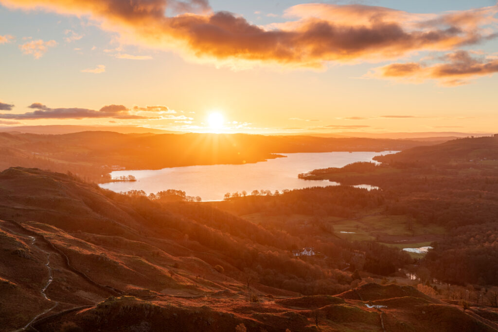 orange lit landscape view of windermere at sunrise