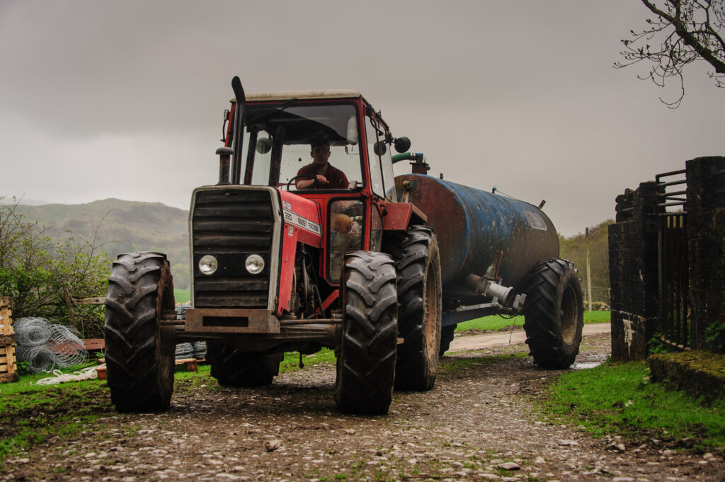 farmer in a red tractor with trailor