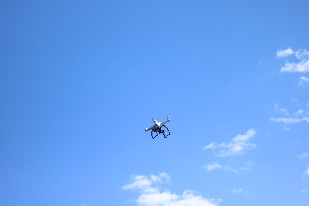 blue sky, few white clouds, drone hovering