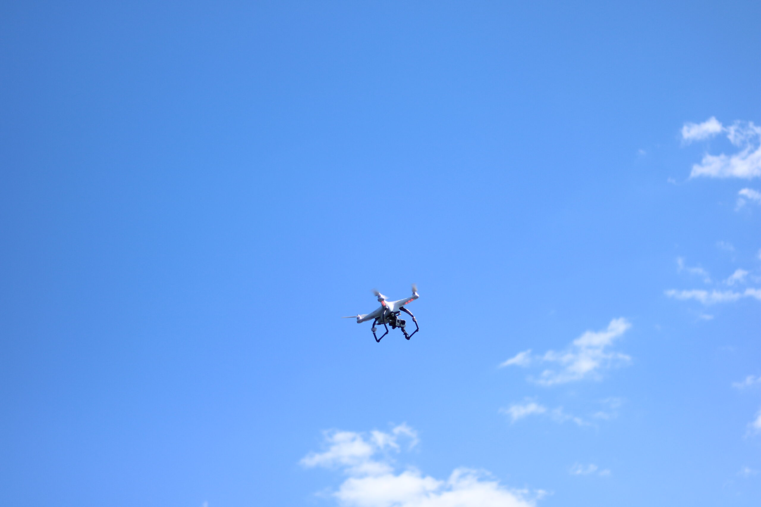 blue sky, few white clouds, drone hovering