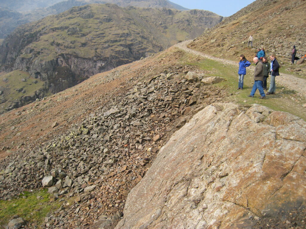 people standing on a path next to rocks
