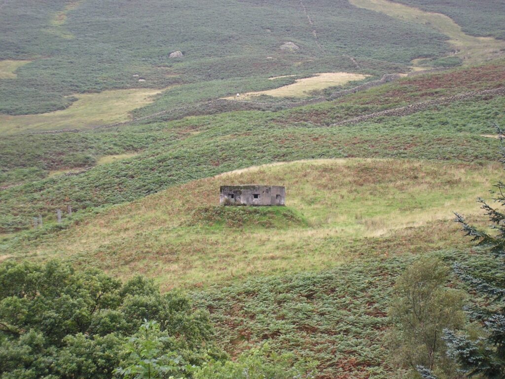 An old pill box concrete builing with square holes on Dunmail Rise dating back to WW2