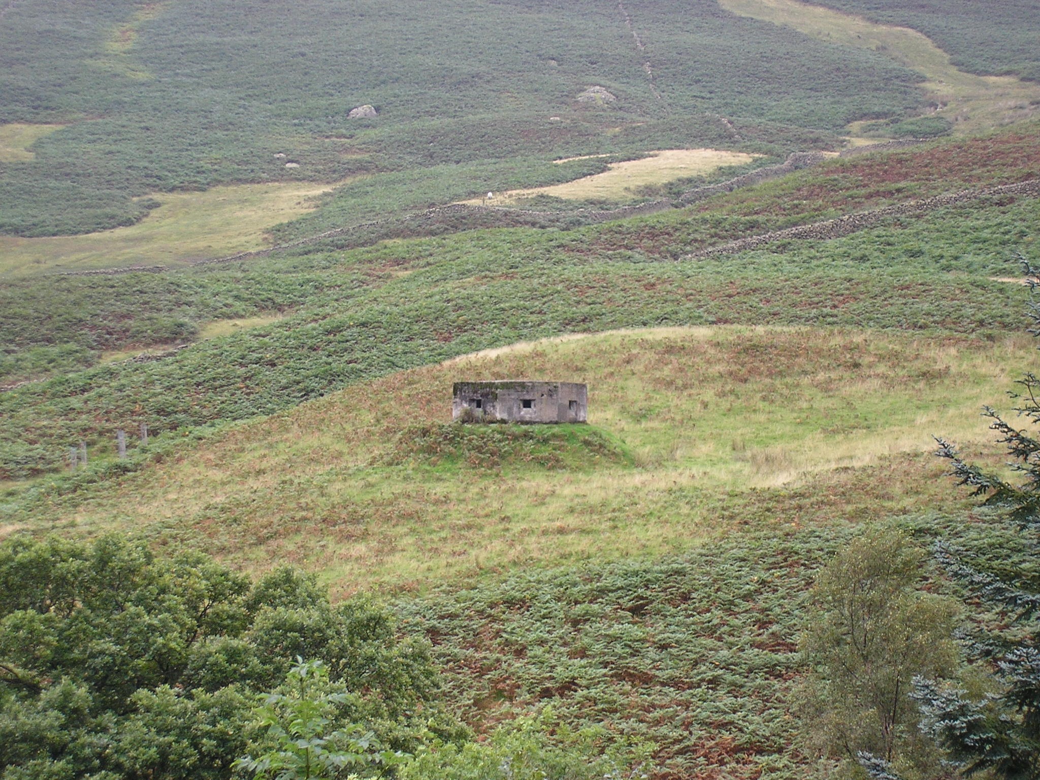 An old pill box concrete builing with square holes on Dunmail Rise dating back to WW2
