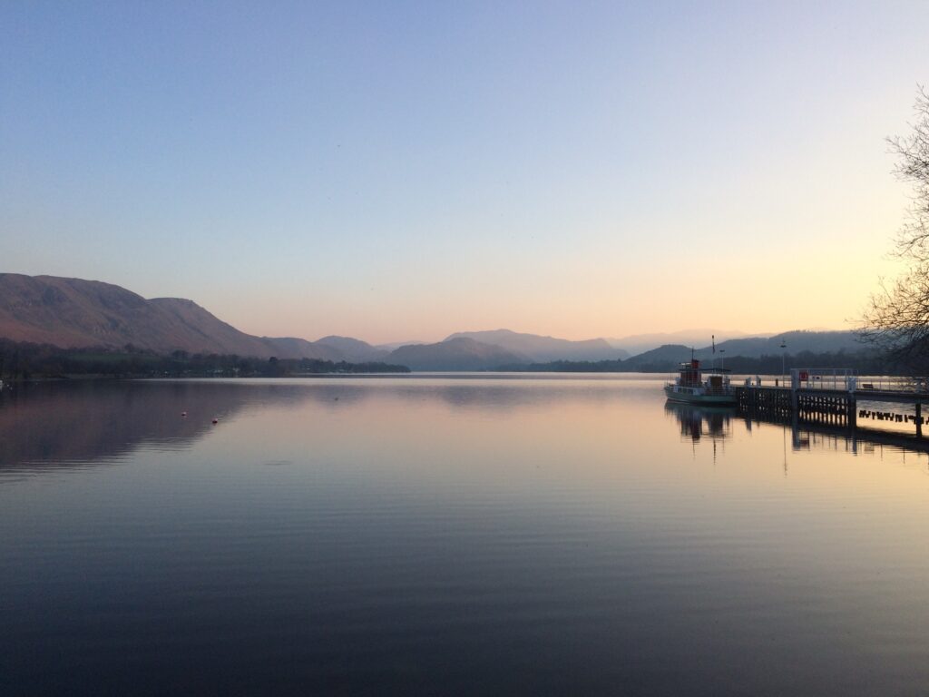 sunset and clear sky looking out over ullswater with jetty to right