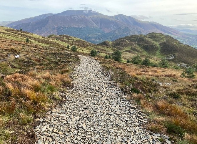 A path in the middle of peatland and a fell in the background