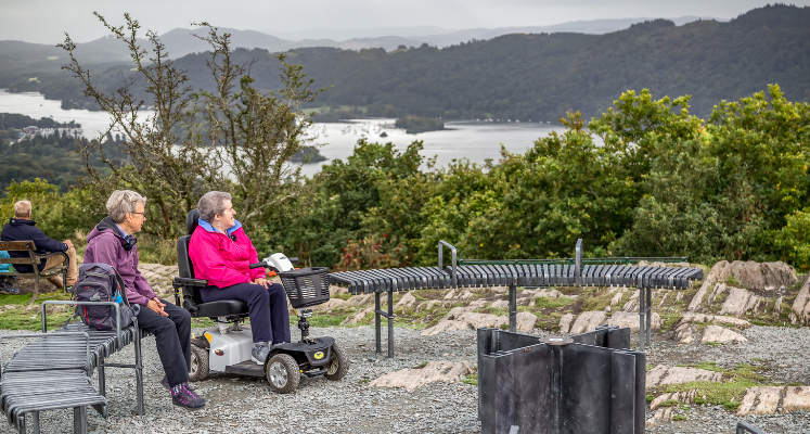 Two women in wheelchairs sat at the top of Orrest Head overlooking Windermere