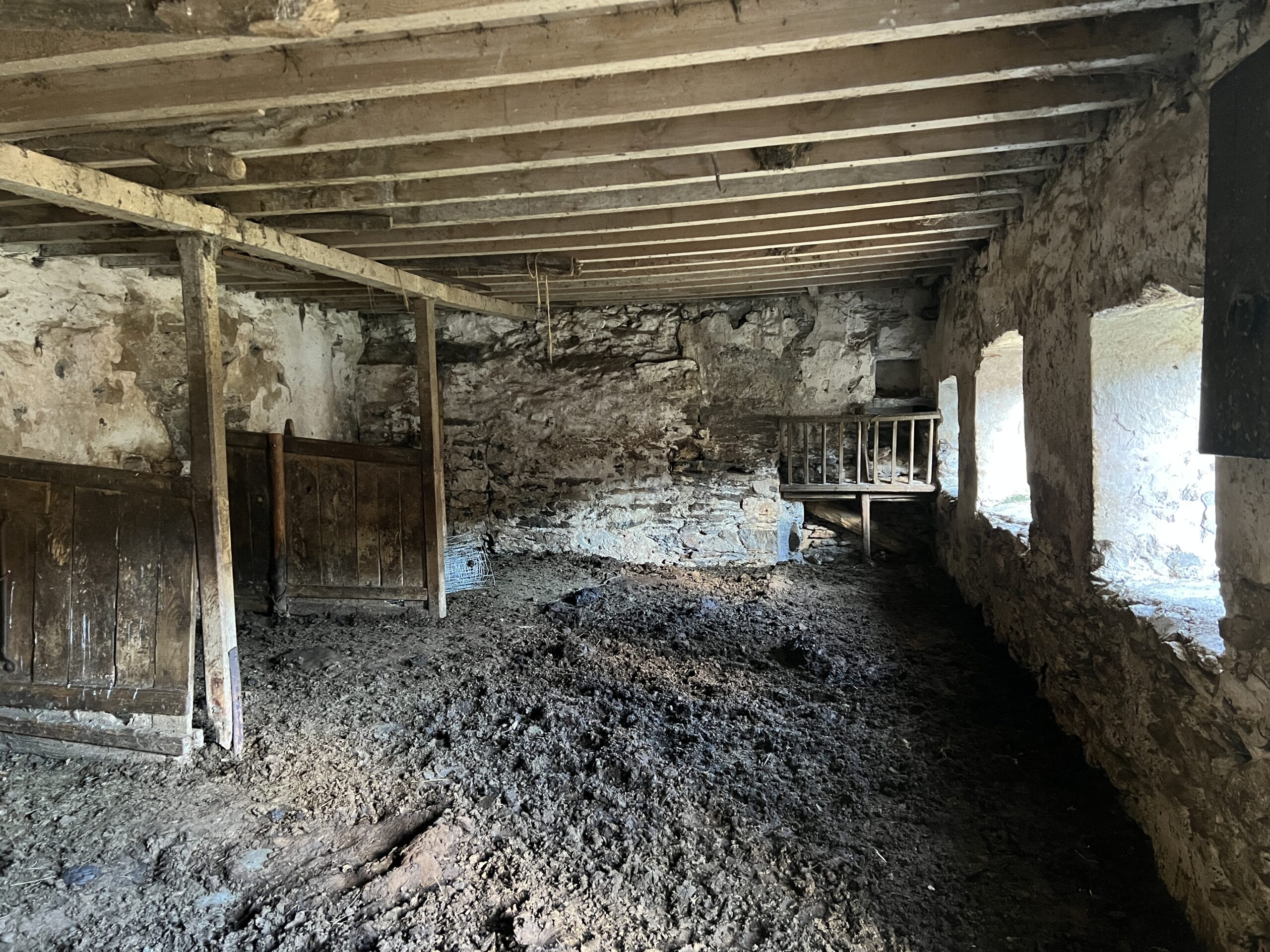 Former living area with door to left and niches to right of hearth