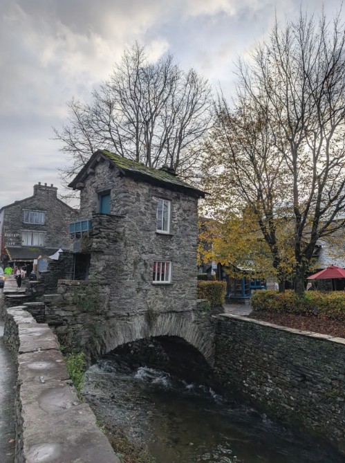 Small stone house atop a bridge over river