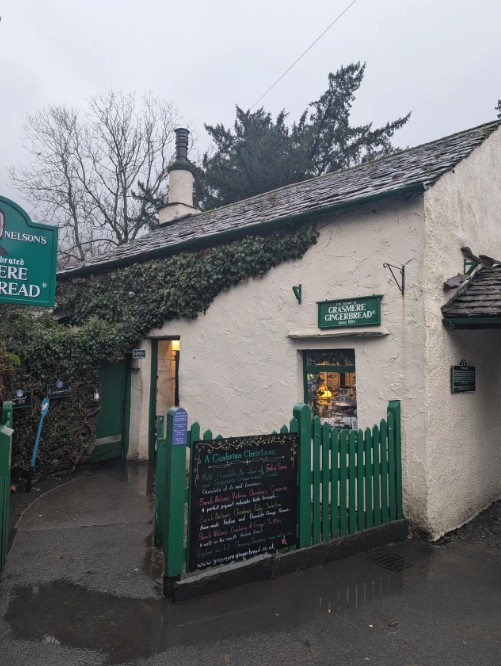 Gingerbread shop with warm lights and greenery growing over stone frontage