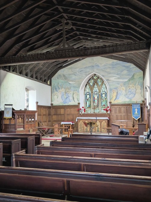 ornate interior of church with pews and mural on wall