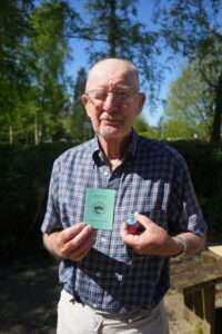 Ron Wood holding his appointment to Warden brochure and badge