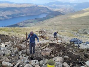 rangers working with stone on mountainside path