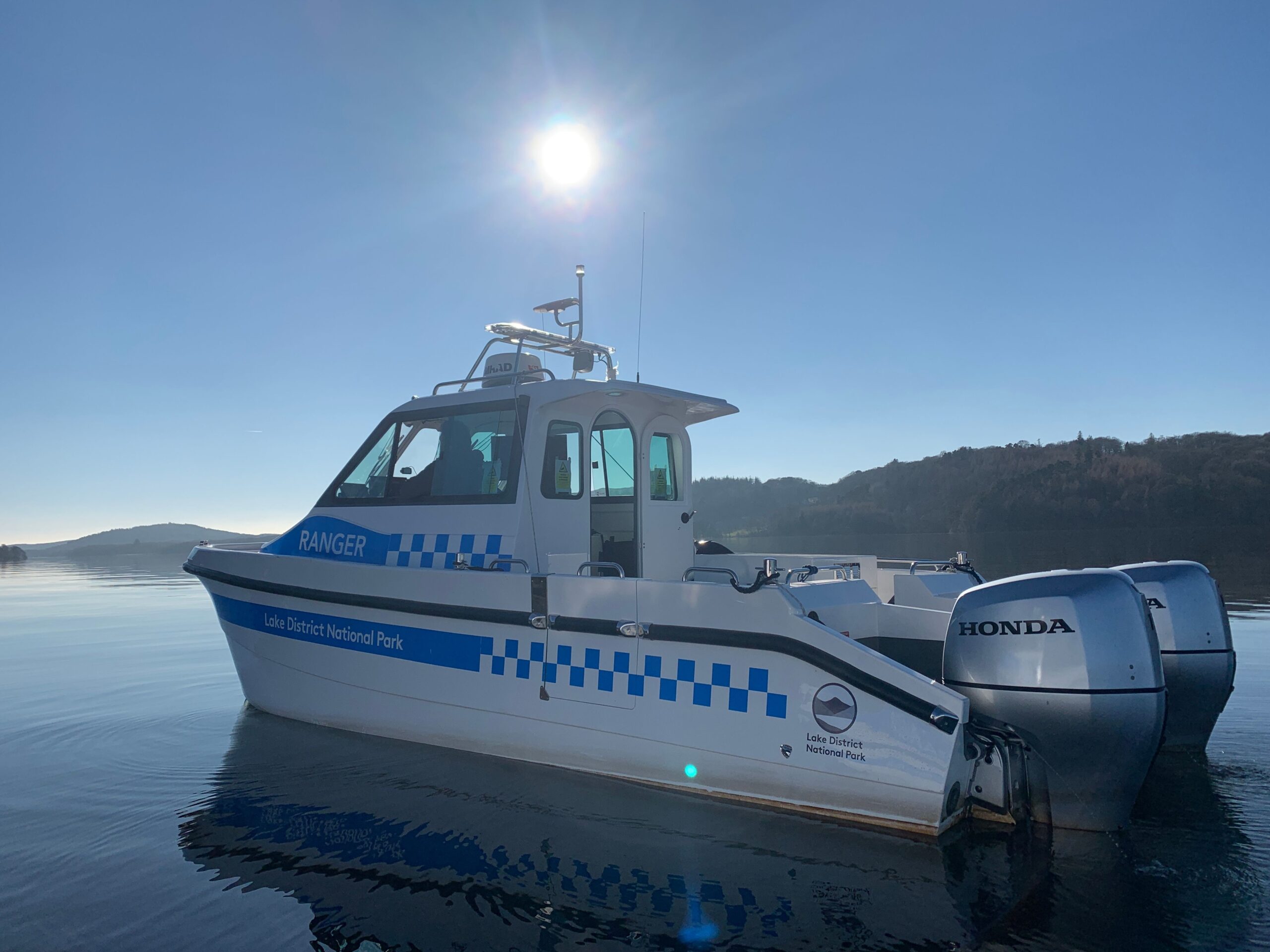 white lake ranger motorised boat on Windermere in the sun
